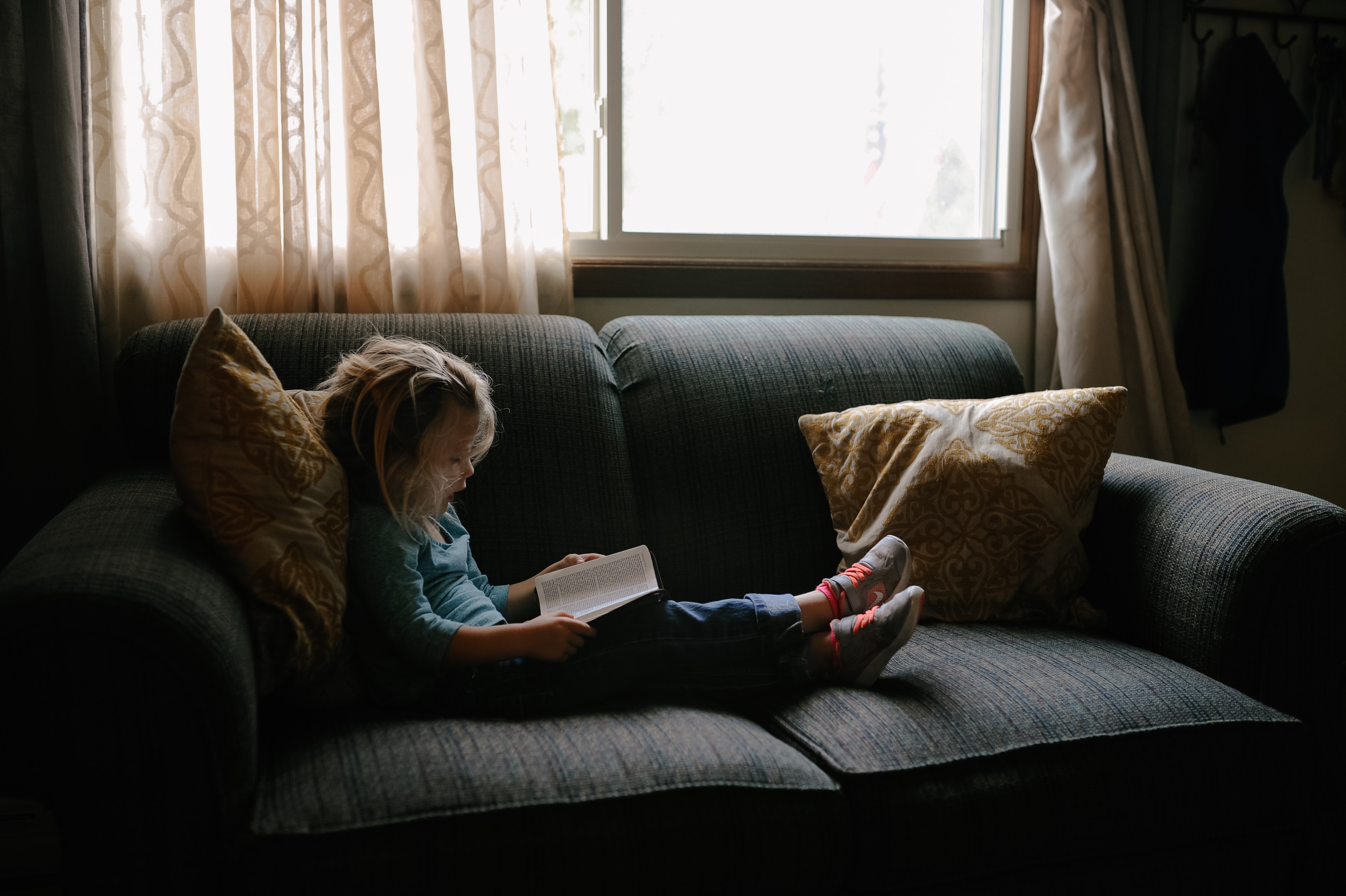 The window is the sofa. Диван для чтения книг. Ребенок сидит на диване. Читать на диване. Читает книгу на диване.